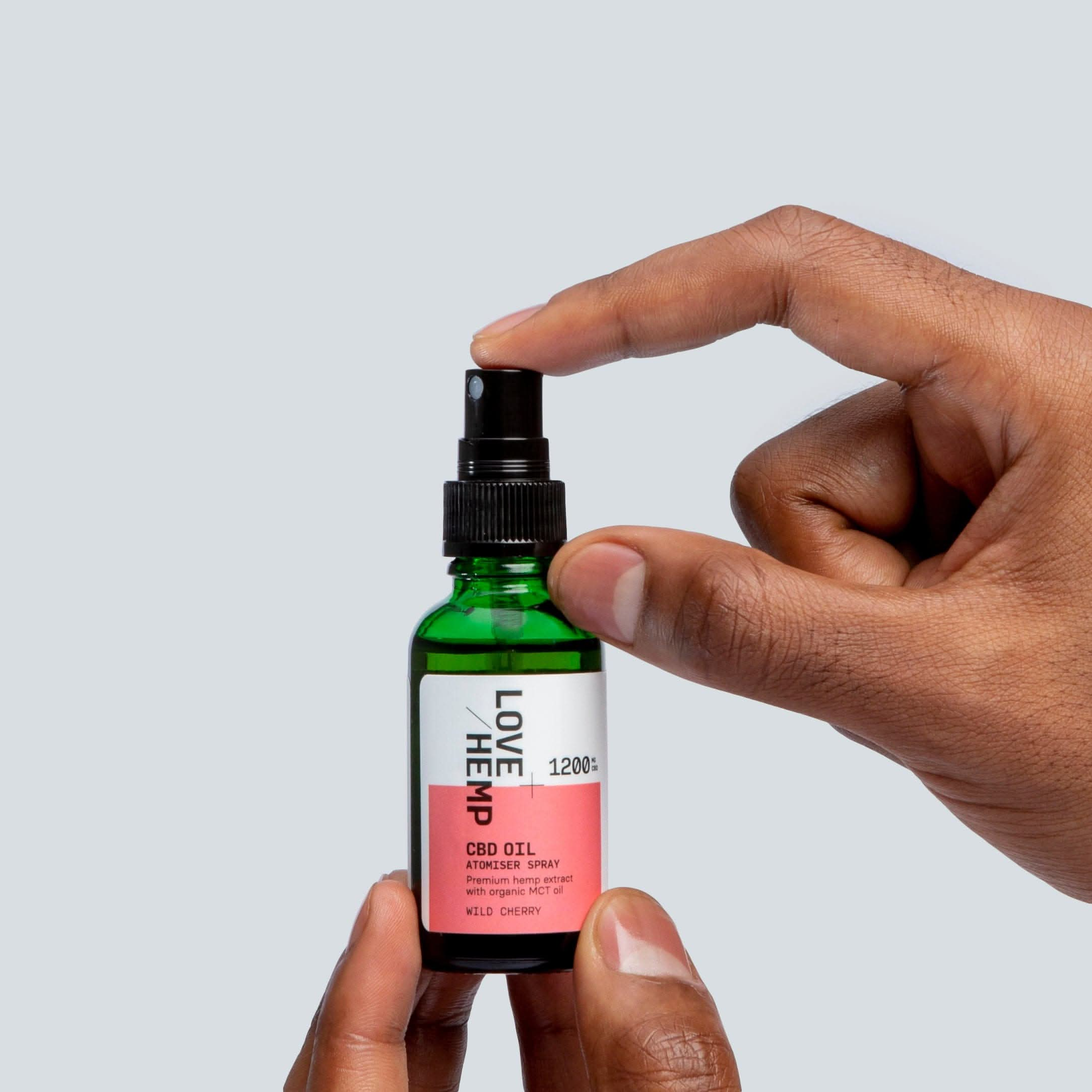 hand holding CBD Oil Spray 1200mg wild cherry