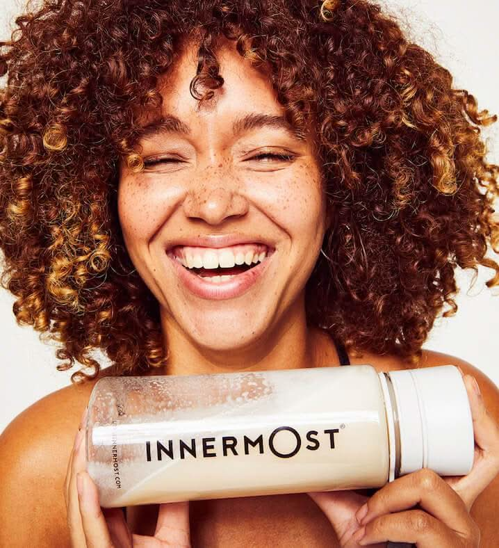 Lulu Stone laughing while holding an Innermost shaker bottle